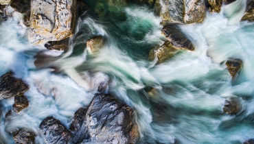 Ein Flussbett, das den Weg des Wassers lenkt: Das Wasser ist die Kommunikation – sie fließt wild oder versiegt. Das Flussbett ist die Führung. Wenn das Bett falsch gegraben ist, nützt es nichts, mehr Wasser hineinzuschütten.